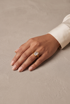 Emerald-cut crystal bezel ring in gold worn on the hand